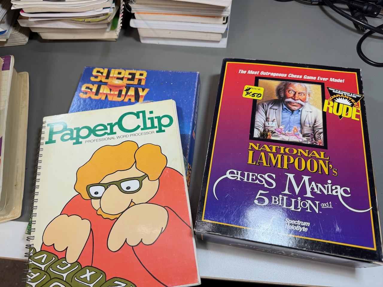 PaperClip word processor manual (box and disks in another photo); National Lampoon's Chess Maniac 5 Billion and 1 for PC; Super Sunday for C64 box