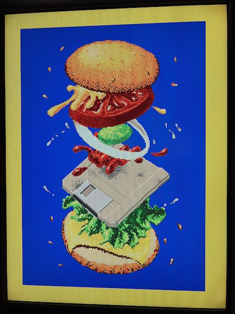 Four-Byte Burger (1985) by Jack Haeger, recreated by Stuart Brown aka Ahoy, displayed on a MEGA65 and rotated 90 degrees